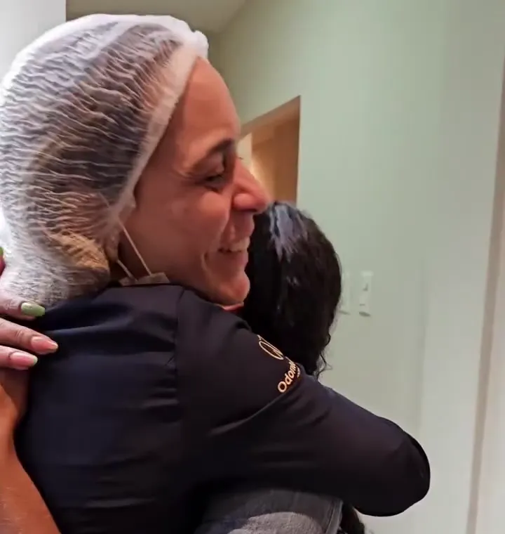 Dentista da clínica abraçando uma paciente